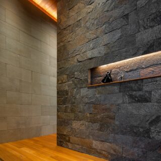 玄関ホール。チーク天井と奥の石壁はLDKまでひと続き。黒雲母入りの石壁は厚みを出し、重厚感を表現