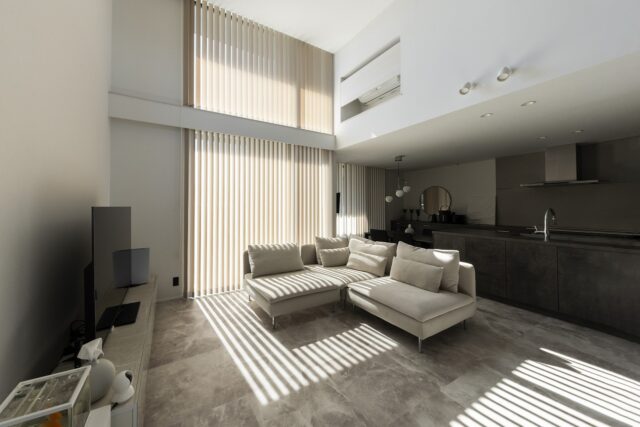 LDK。クライアントの「ホテルライクな室内空間」という要望に応え、冷蔵庫や電子レンジ、エアコンなどの家電をなるべく目立たない設計に。床は大理石調のフロアタイルを採用