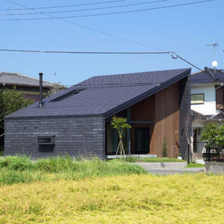 西側の田園から見た外観。狭い生活道路に面している西側にはあえて大きな窓を設けず、まるで隠れ家のようだ。西側に流れる屋根としたことで高さが抑えられ、道路を歩く人に圧迫感を与えていないことがよくわかる
