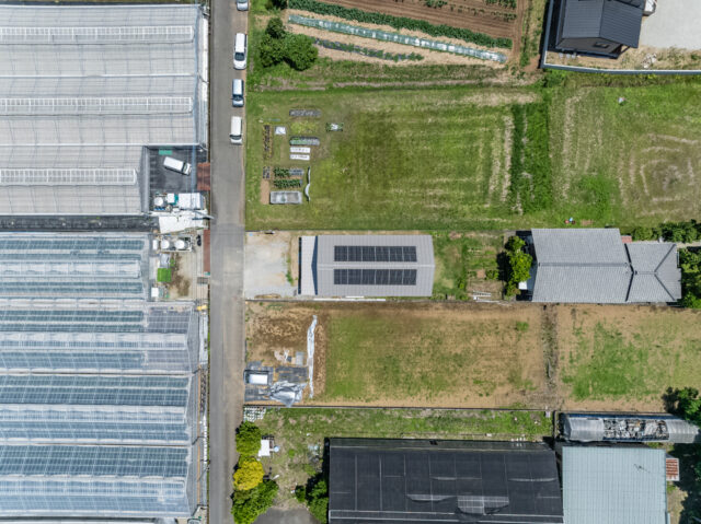 敷地全体をドローンで上空から撮影。敷地の両サイドはもともと田だった土地で、市街化調整区域内にあるため隣家が建ちにくい。左側に見えるのはミニトマトのビニールハウスだ
