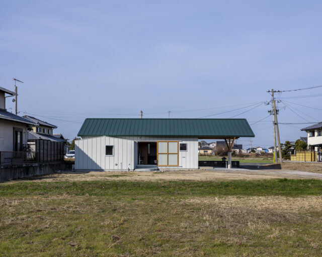 外観（東側）。とても珍しい、大屋根の張り出し。駐車場をすべて覆っていることがわかる。　構造設計の専門家の協力を得て実現した。リビングの大きな引戸は全開することができる
