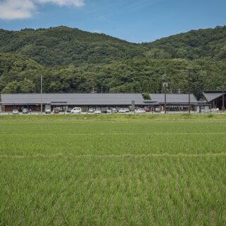 横長の建物が、同じく横長に伸びた背後の山々にしっくり馴染む。地元の杉や石州瓦をふんだんに使った建築は、周囲の自然に見事に調和。“むくり”をつけた瓦屋根が、ごくわずかに膨らんでいるのがわかる